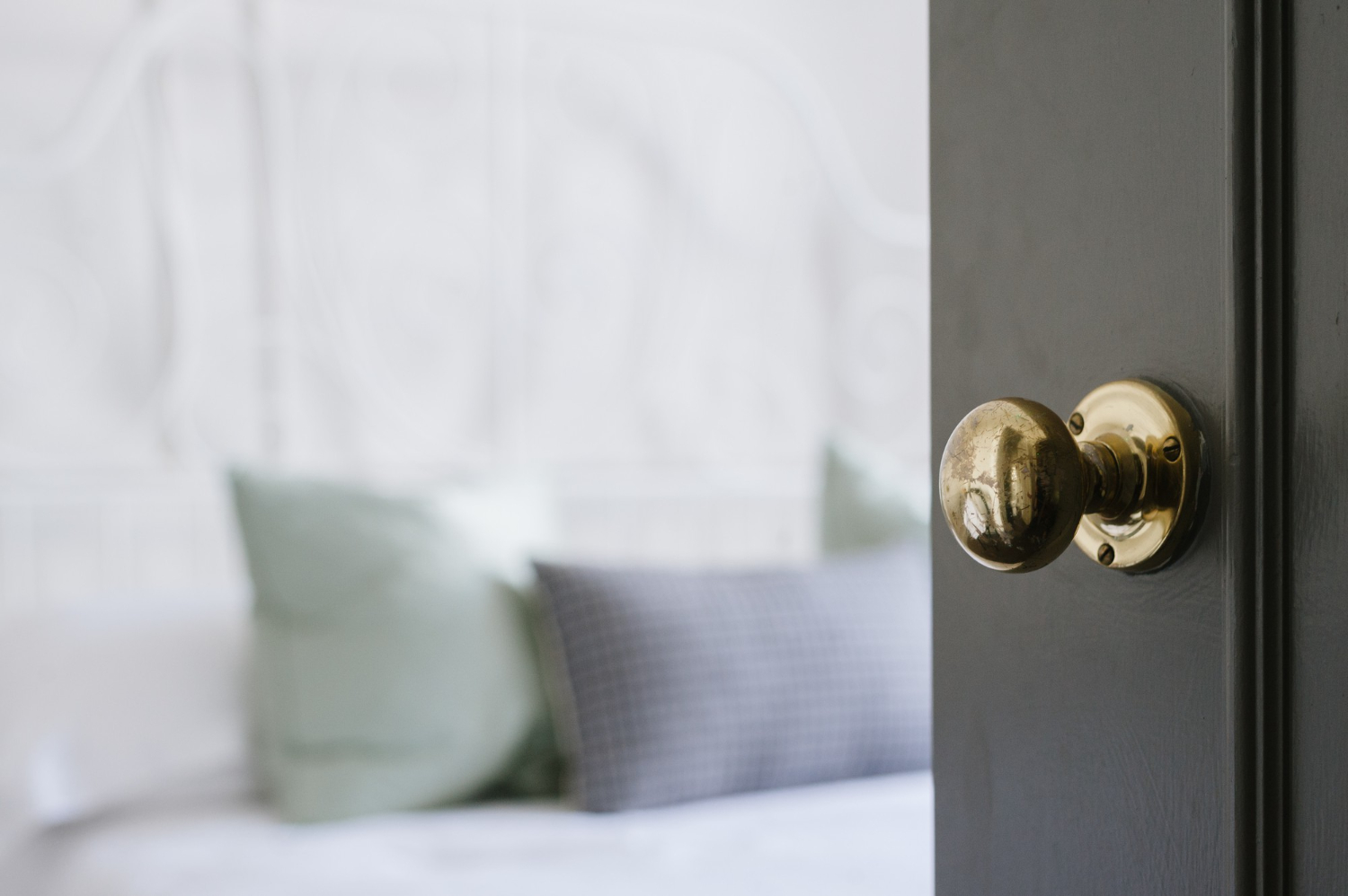 Brass doorknob with blurred bedroom background