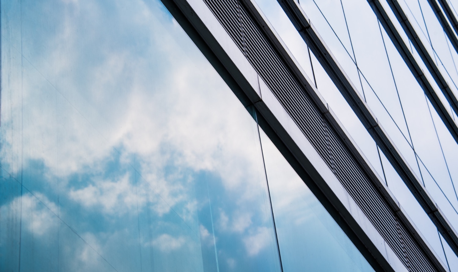 Reflective glass building with clouds