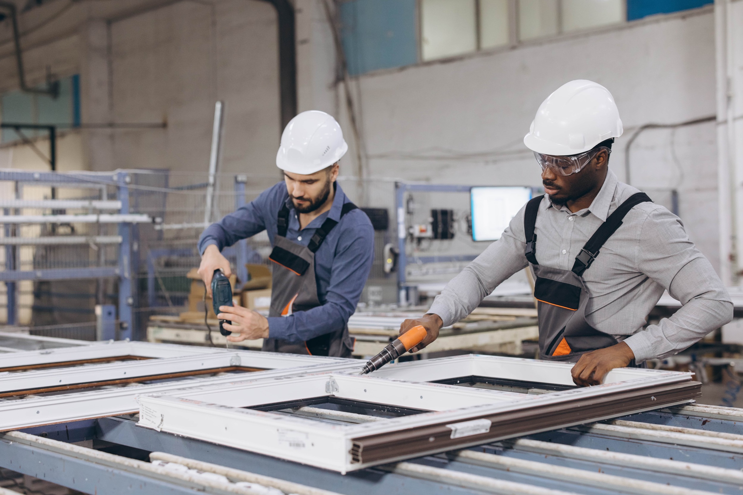 Workers assembling PVC windows and doors.